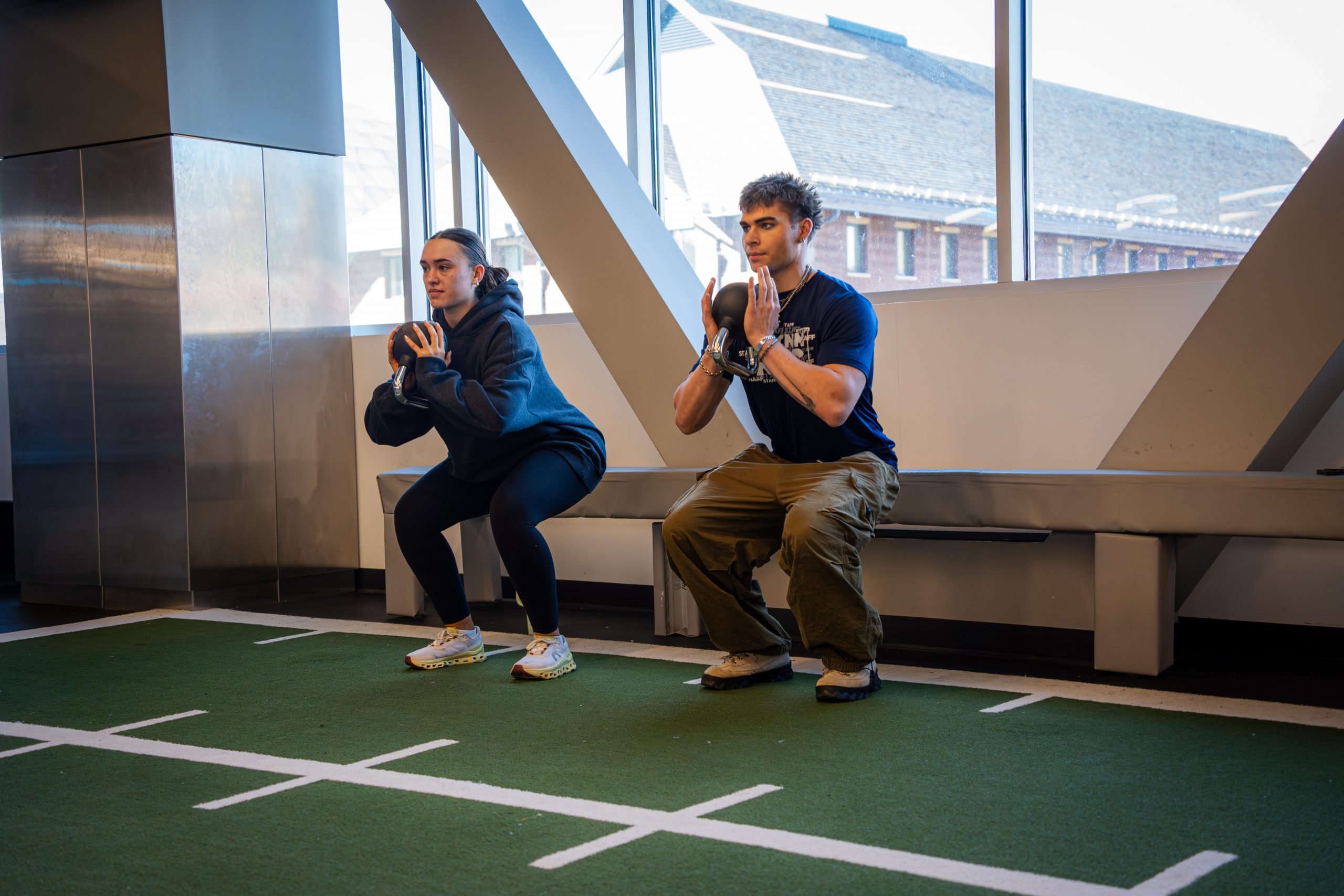 Personal trainer and participant completing a squat